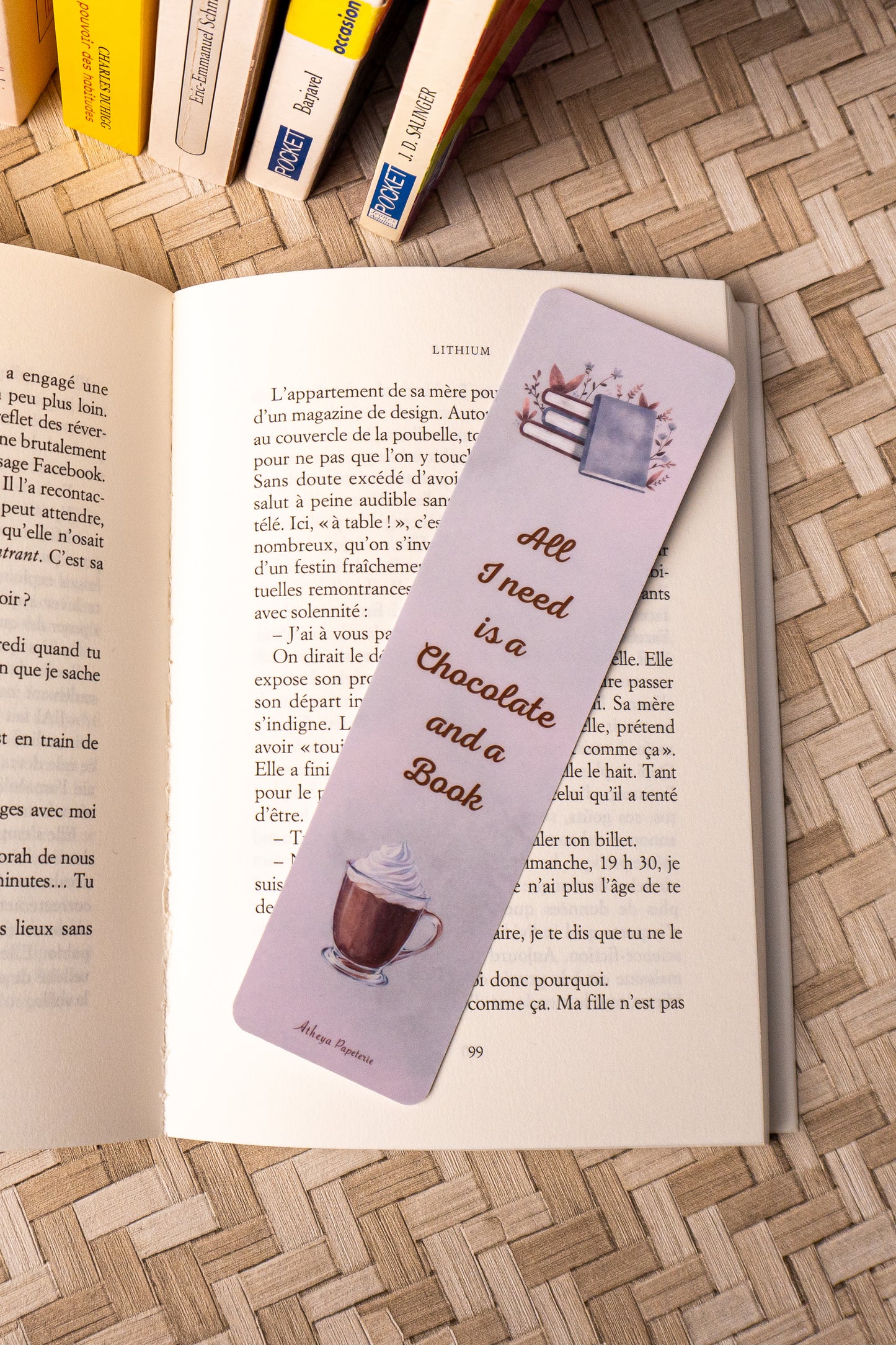 Marque-pages sur lequel on peut lire "All I need is a Chocolate and a Book" avec au dessus de la citation une jolie pile de livre et en dessous, le dessins d'un beau chocolat chaud.