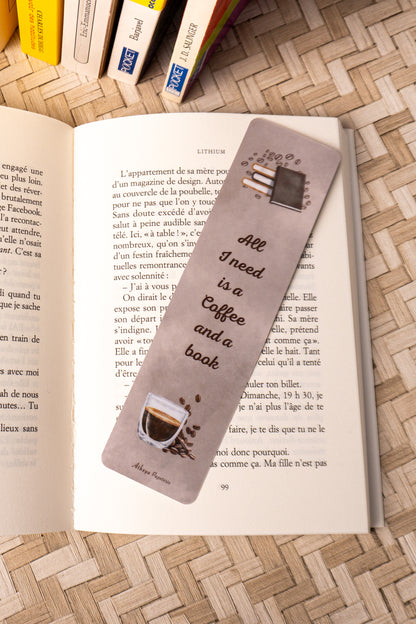 Marque-pages sur lequel on peut lire "All I need is a Coffee and a Book" avec au dessus de la citation une jolie pile de livre et en dessous, le dessins d'un beau café.