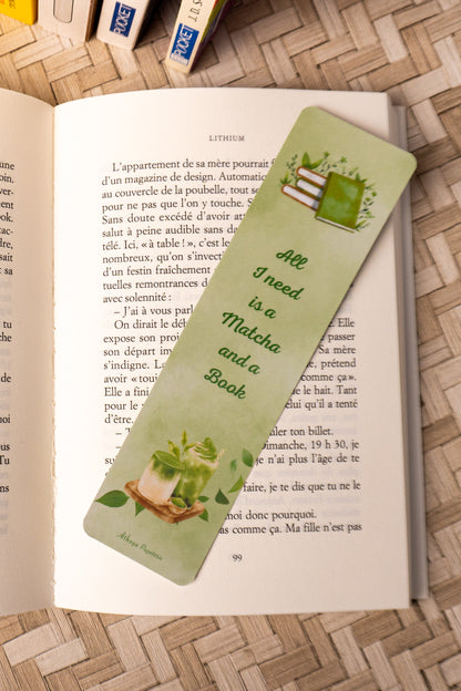 Marque-pages sur lequel on peut lire "All I need is a Matcha and a Book" avec au dessus de la citation une jolie pile de livre et en dessous, le dessins d'un beau matcha.