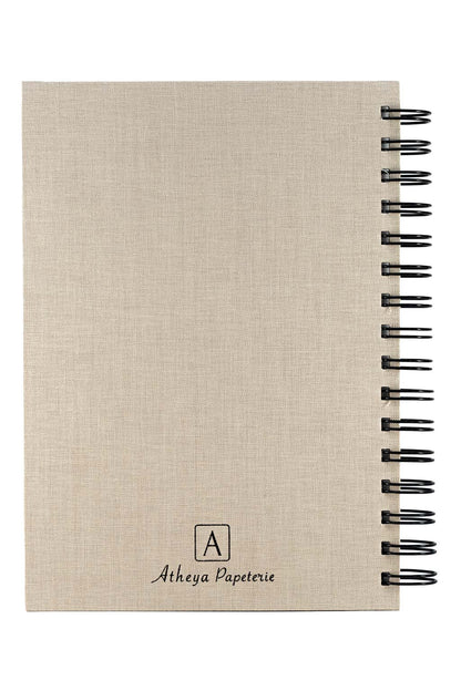 Photo brute de la quatrième de couverture du carnet "Mon Carnet" recouvert d'une toile beige et  avec l'inscription "Atheya Papeterie" ainsi que la spirale de couleur noire. Il n'y a aucun autre élément sur la photo, uniquement le carnet sur fond blanc.